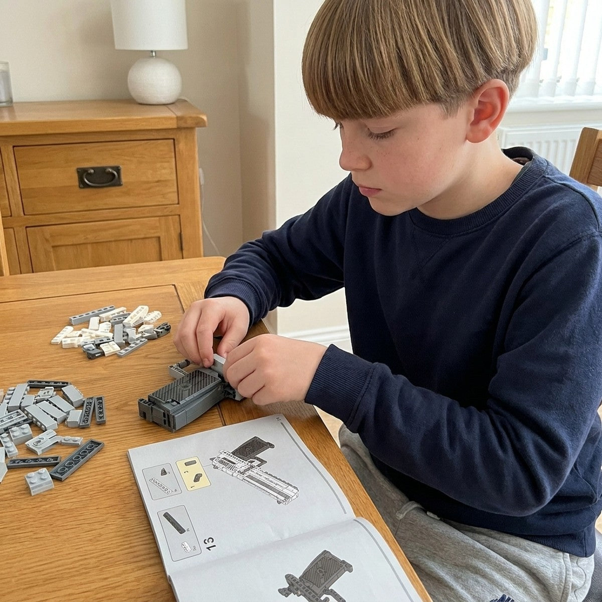 Boy building the Magnum Eagle brick pistol himself at his desk